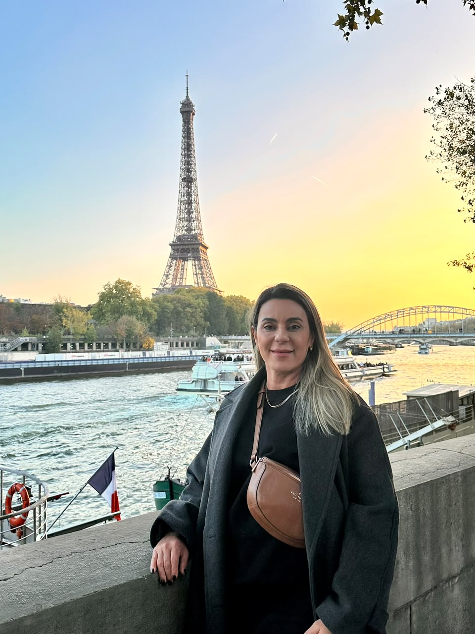 Carolina Andrade às margens do Sena com a Torre Eiffel ao fundo, em Paris