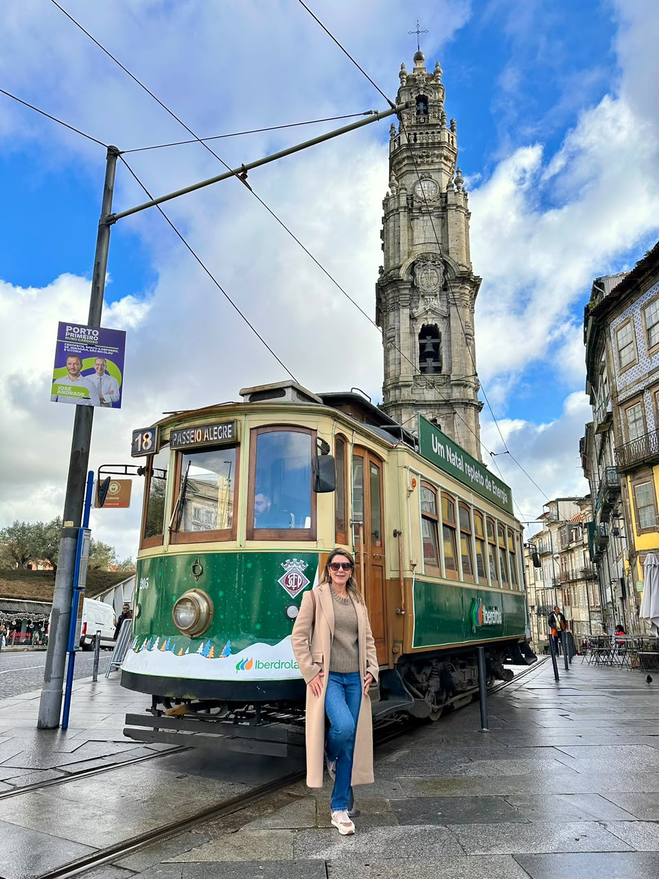 Carolina Andrade ao lado do bonde histórico com a Torre dos Clérigos ao fundo, no Porto